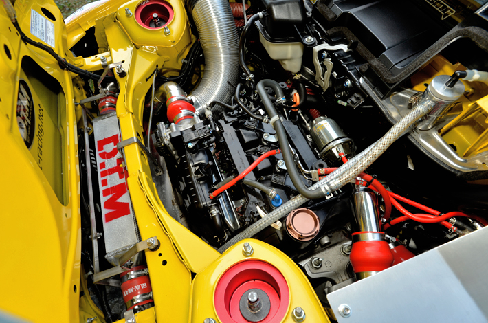 ルックスも意識し、色合いや配管の取り回しを意識したエンジンルーム。性能もさることながら、美観にもこだわり、美しく仕上げました。 インタークーラー中央部にはウォータースプレーを配置し、電動ファンとの組み合わせにより冷卸効率を向上させ、真夏のサーキット走行時でも吸気温度は最高でも55度程度まで抑えられています。